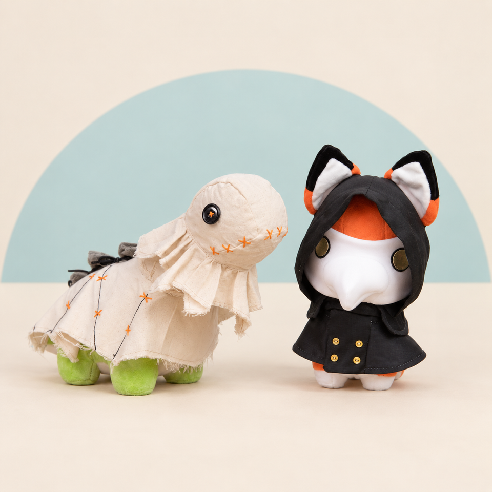 Scarecrow Bronti and Plague Doctor Foxxi on a cream and soft blue studio background